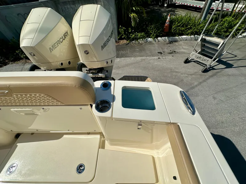 Slide: The Image of 2025 Scout 277 LXF boat with dual Mercury engines, beige seating, and cup holders. - 16