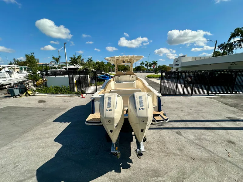 Slide: The Image of 2025 Scout 277 LXF boat with dual outboard engines in a sunny marina setting. - 20