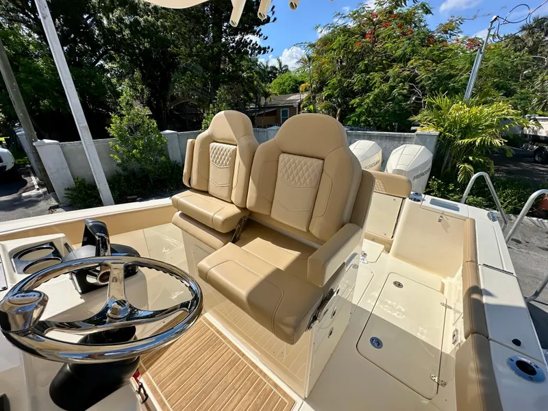 Slide: The Image of 2025 Scout 277 LXF boat interior with beige seating and steering wheel. - 4