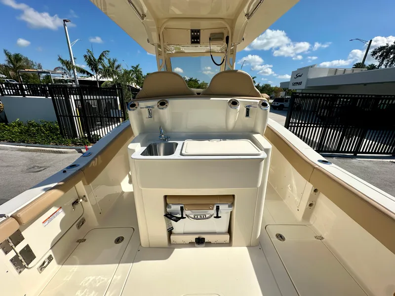 Slide: The Image of 2025 Scout 277 LXF boat interior with sink and storage, sunny day. - 5