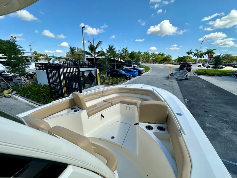 Slide: The Image of 2025 Scout 277 LXF boat interior with seating, cup holders, and clear blue sky. - 6