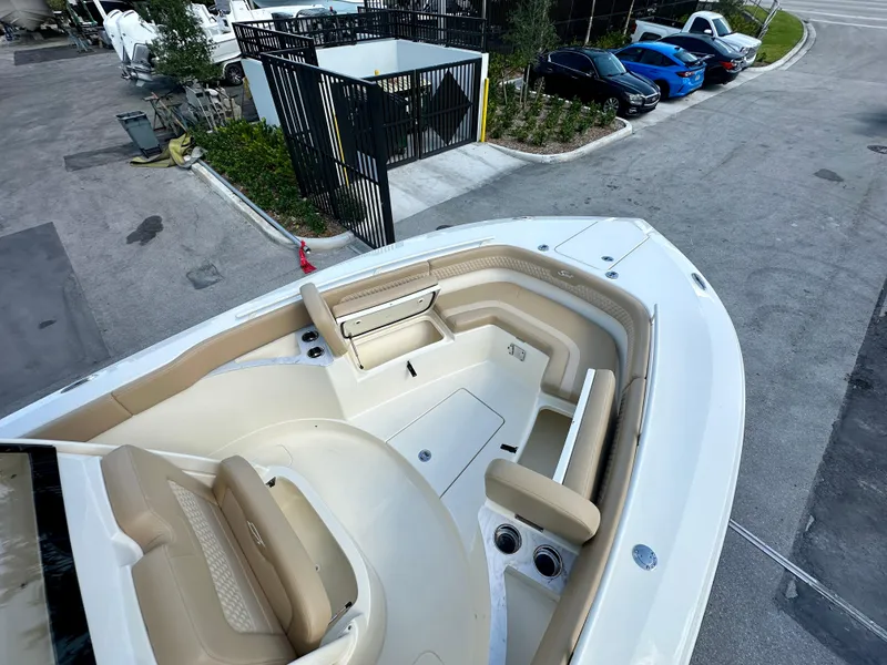 Slide: The Image of 2025 Scout 277 LXF boat with spacious seating and modern design in a parking area. - 9