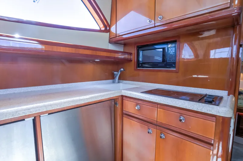 Slide: The Image of Luxurious kitchen area in a 2005 Bertram 450 Convertible yacht with wood cabinetry. - 13
