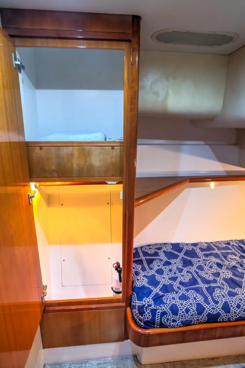 Slide: The Image of Interior cabin of 2005 Bertram 450 Convertible yacht with wooden finish and blue bedding. - 18