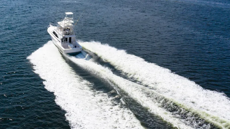 Slide: The Image of 2005 Bertram 450 Convertible yacht cruising on open water, leaving a wake behind. - 2