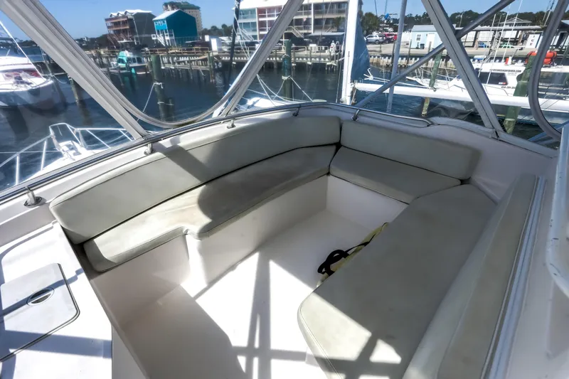 Slide: The Image of 2005 Bertram 450 Convertible yacht interior with spacious seating and marina view. - 26