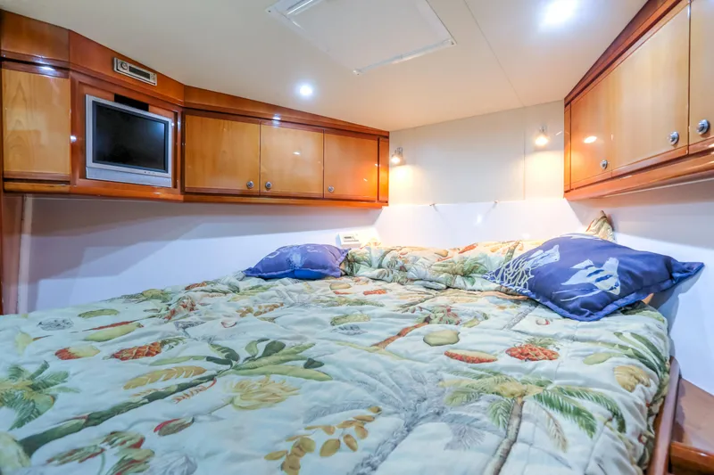 Slide: The Image of Luxurious cabin interior of 2005 Bertram 450 Convertible with cozy bedding and wooden cabinets. - 29
