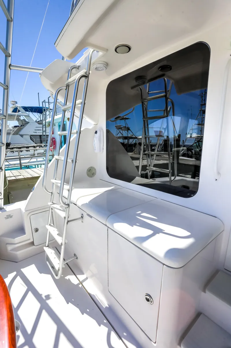 Slide: The Image of Bertram 450 Convertible 2005 yacht deck with ladder and window, docked at marina. - 36