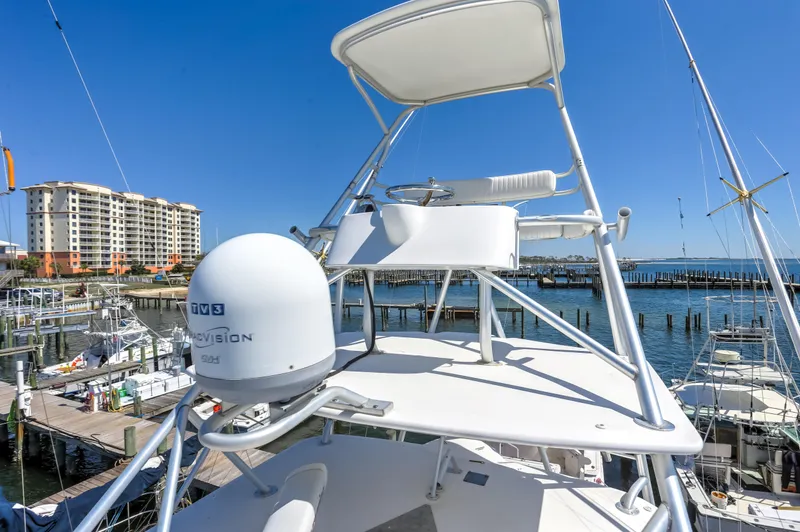 Slide: The Image of 2005 Bertram 450 Convertible yacht with radar, docked at marina under clear blue sky. - 46