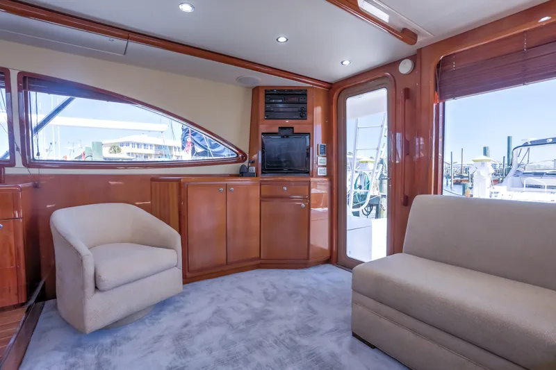 Slide: The Image of Interior of 2005 Bertram 450 Convertible yacht with plush seating and wooden cabinetry. - 7