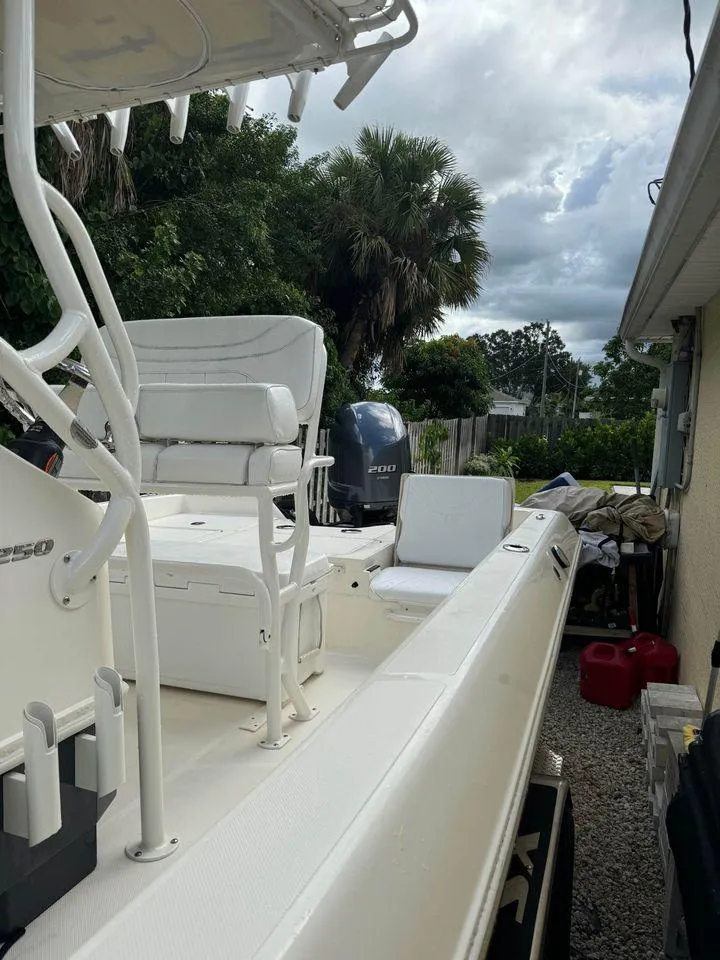 Slide: The Image of 2022 Skeeter SX2250 boat with white seating, parked outdoors near trees. - 11