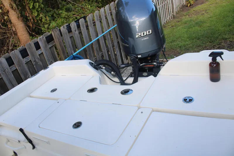 Slide: The Image of 2022 Skeeter SX2250 boat with Yamaha 200 engine, parked near wooden fence. - 19