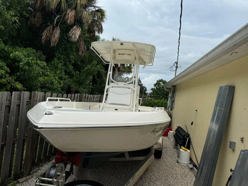 Slide: The Image of 2022 Skeeter SX2250 boat parked beside a house, surrounded by trees and a fence. - 5