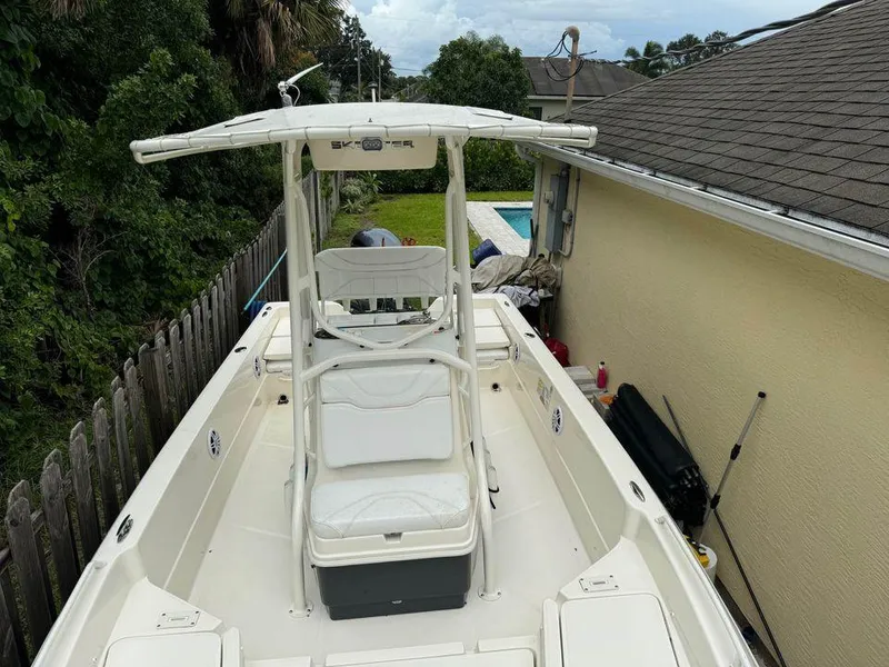 Slide: The Image of 2022 Skeeter SX2250 boat with T-top, parked beside a house and pool. - 6