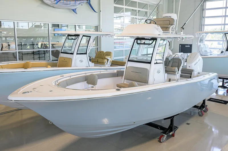 Slide: The Image of 2024 Sportsman Open 252 Center Console boat displayed in a showroom. - 0