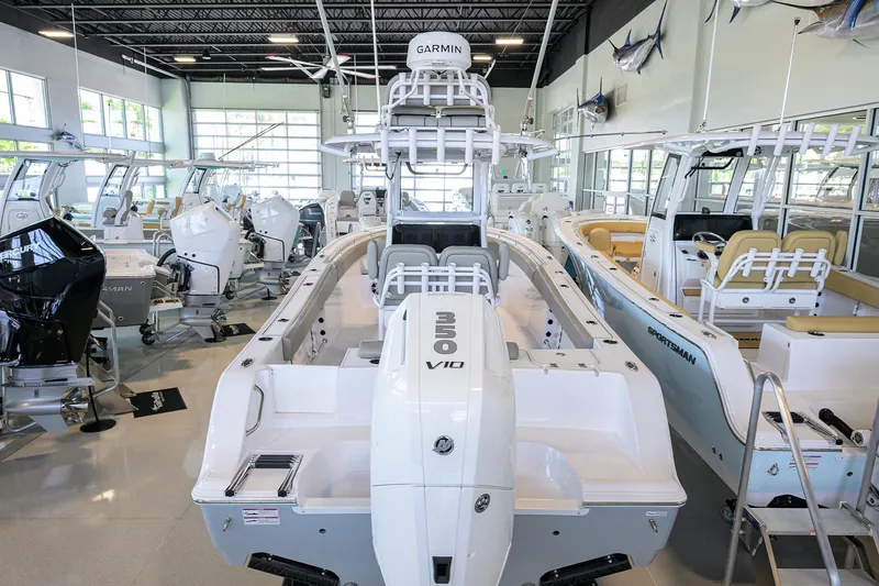 Slide: The Image of 2024 Sportsman Open 252 Center Console boat displayed in a showroom with other boats. - 1