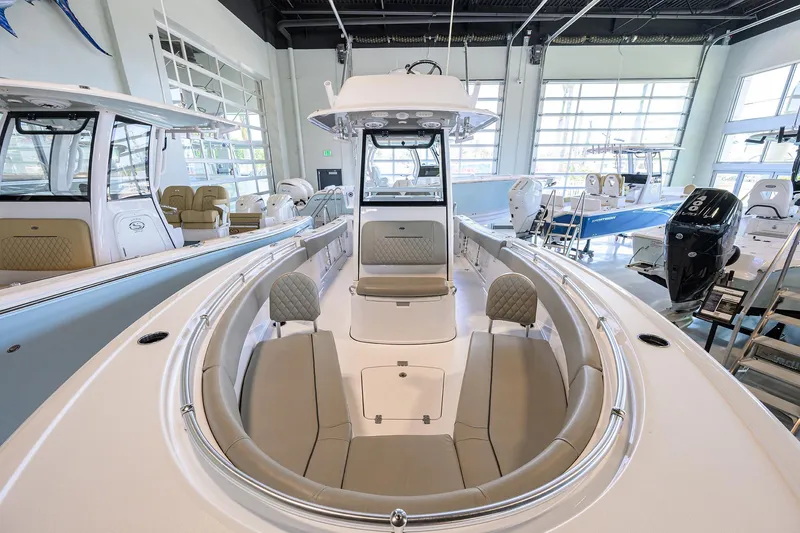Slide: The Image of 2024 Sportsman Open 252 Center Console boat interior, showcasing seating and helm in a showroom. - 11