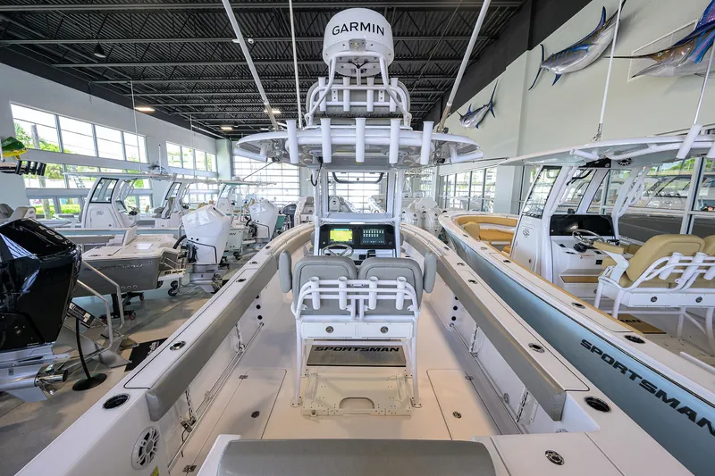 Slide: The Image of 2024 Sportsman Open 252 Center Console boat in showroom, featuring Garmin electronics. - 19