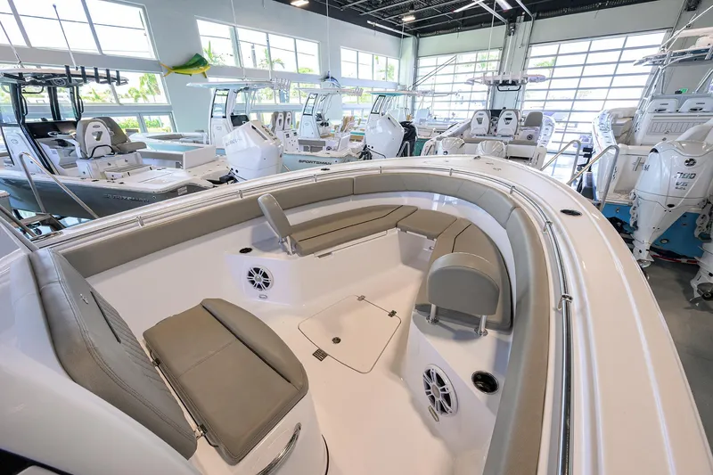 Slide: The Image of 2024 Sportsman Open 252 Center Console boat interior in showroom, featuring seating and modern design. - 8