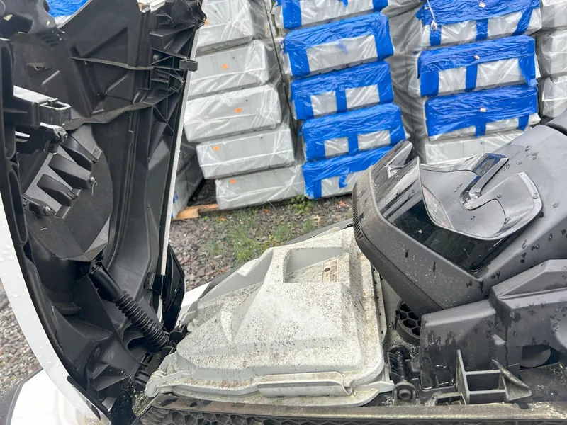 Slide: The Image of 2012 Sea-Doo GTX 155 engine compartment with open cover, stacked boxes in background. - 28