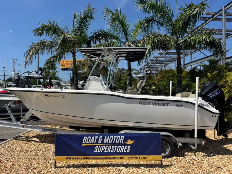 The Image of 2022 Key West 239 FS boat displayed at dealership with palm trees in background. - 1