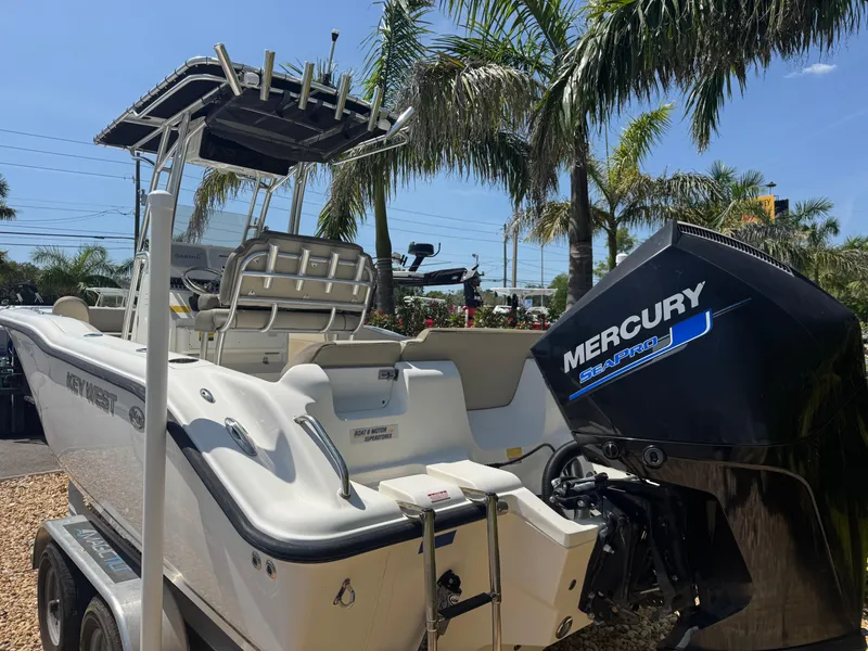 Slide: The Image of 2022 Key West 239 FS boat with Mercury engine, parked near palm trees. - 10