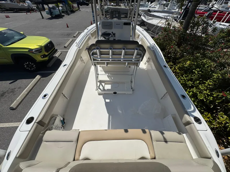 Slide: The Image of 2022 Key West 239 FS boat interior with seating and console, parked near a green vehicle. - 11