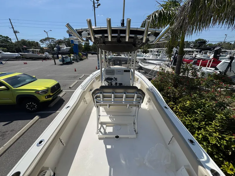Slide: The Image of 2022 Key West 239 FS boat, center console view, parked outdoors near greenery and vehicles. - 12