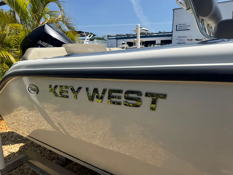 Slide: The Image of 2022 Key West 239 FS boat with logo, parked outdoors under clear sky. - 6