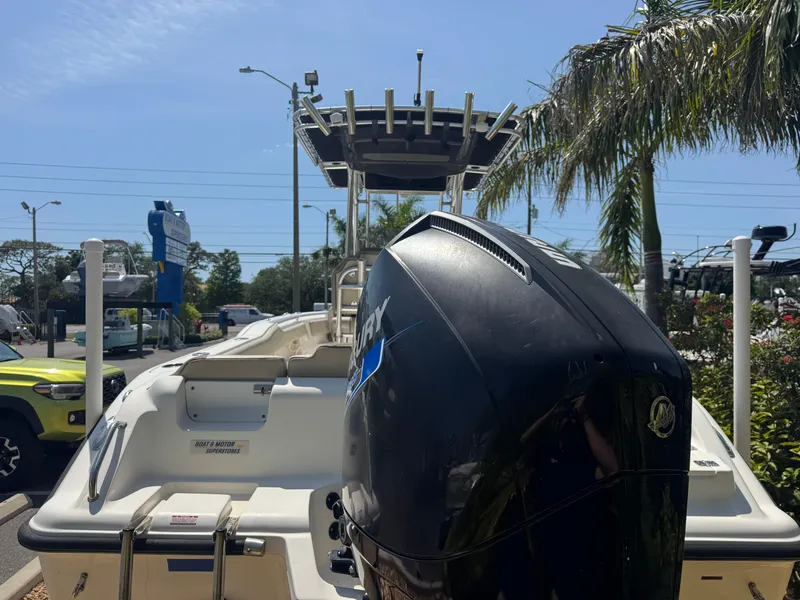Slide: The Image of 2022 Key West 239 FS boat with outboard motor, parked outdoors under clear sky. - 9