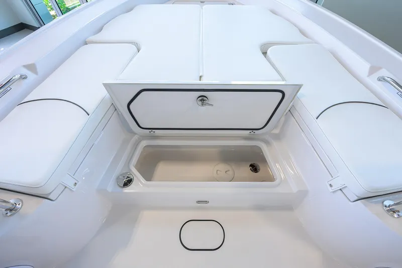 Slide: The Image of 2025 Sportsman Masters 267 Bay Boat interior with open storage compartment and cushioned seating. - 11