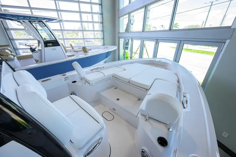 Slide: The Image of 2025 Sportsman Masters 267 Bay Boat interior with white seating in showroom. - 15