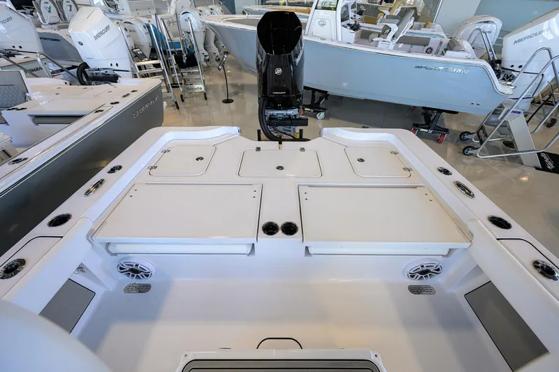 Slide: The Image of 2025 Sportsman Masters 267 Bay Boat interior with storage compartments and motor, displayed in showroom. - 18
