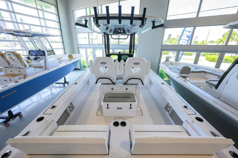Slide: The Image of 2025 Sportsman Masters 267 Bay Boat interior, showcasing seating and console in a showroom. - 22