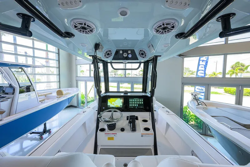 Slide: The Image of 2025 Sportsman Masters 267 Bay Boat interior with modern dashboard and controls in showroom. - 28