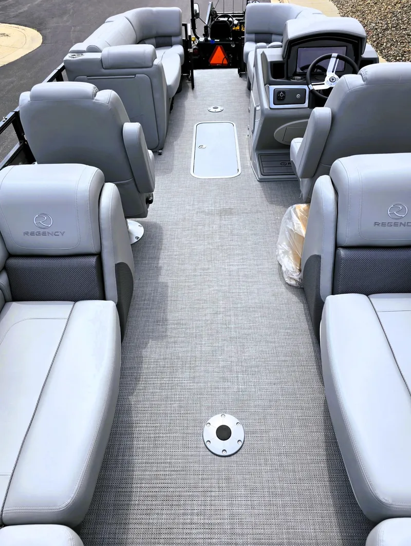 Slide: The Image of 2025 Regency 230 LE3 pontoon boat interior with gray seating and modern dashboard. - 3