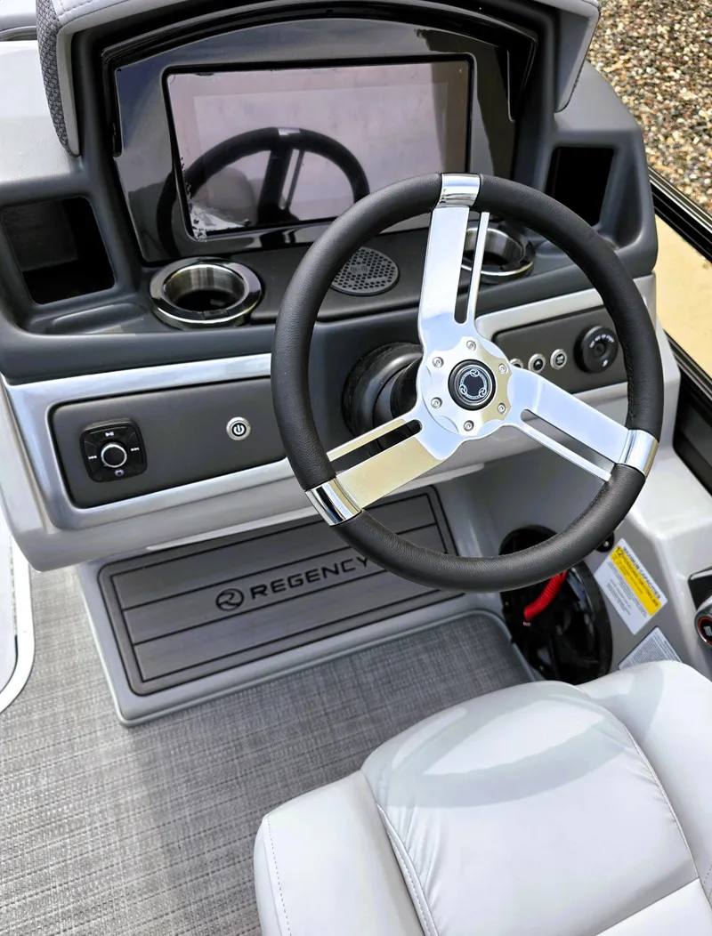 Slide: The Image of 2025 Regency 230 LE3 boat dashboard with steering wheel and modern controls. - 5
