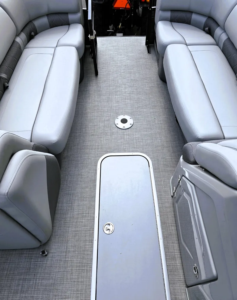 Slide: The Image of 2025 Regency 230 LE3 boat interior with gray seating and carpeted flooring. - 6