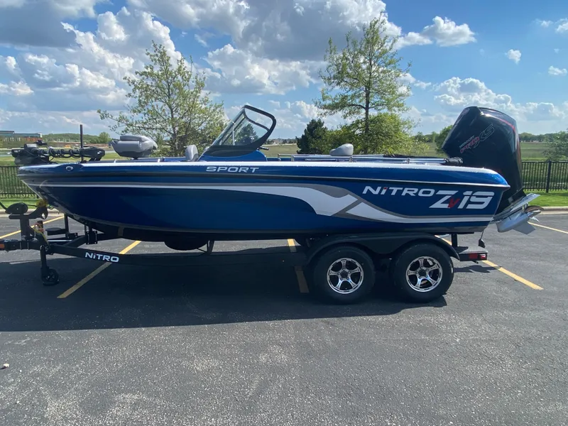 The Image of 2025 Nitro ZV19 Sport Pro boat on trailer, parked outdoors under a blue sky. - 0