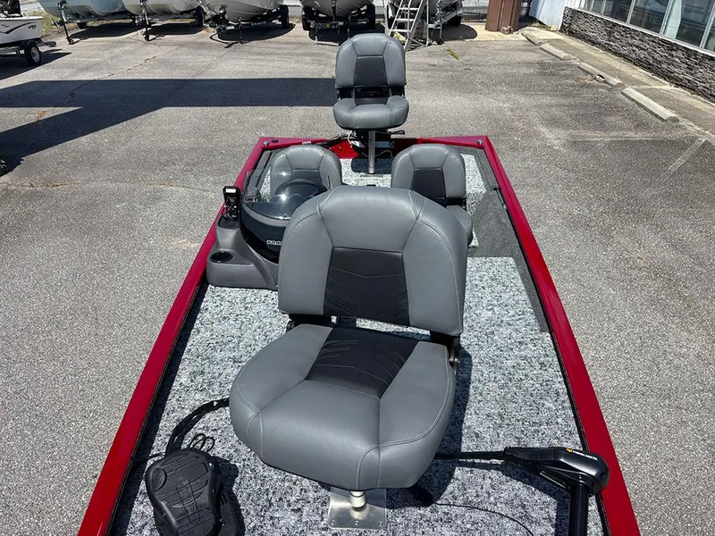 Slide: The Image of 2025 Tracker Pro 170 boat with gray seats and red trim, parked outdoors. - 11