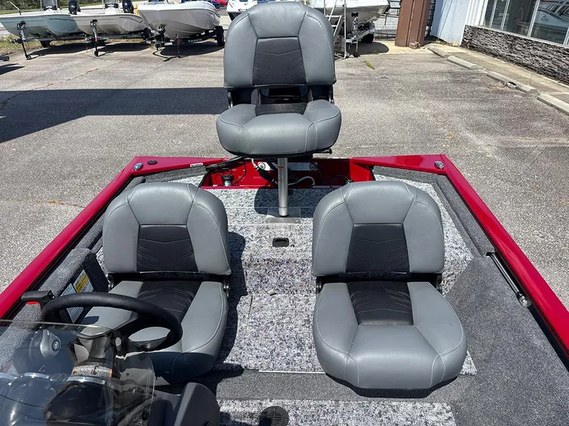 Slide: The Image of 2025 Tracker Pro 170 boat interior with three gray seats, red trim, and steering wheel. - 18
