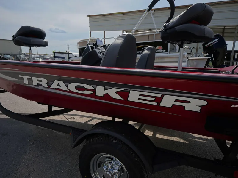 Slide: The Image of 2025 Tracker Pro Team 175 boat with red exterior and black seats on a trailer. - 4