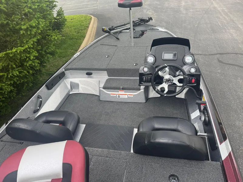 Slide: The Image of 2025 Nitro Z17 boat interior with steering wheel and seating, parked on pavement. - 2