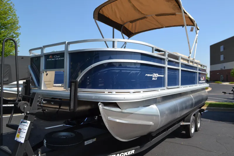 Slide: The Image of 2025 Sun Tracker Fishin' Barge 20 DLX pontoon boat with canopy on trailer. - 2