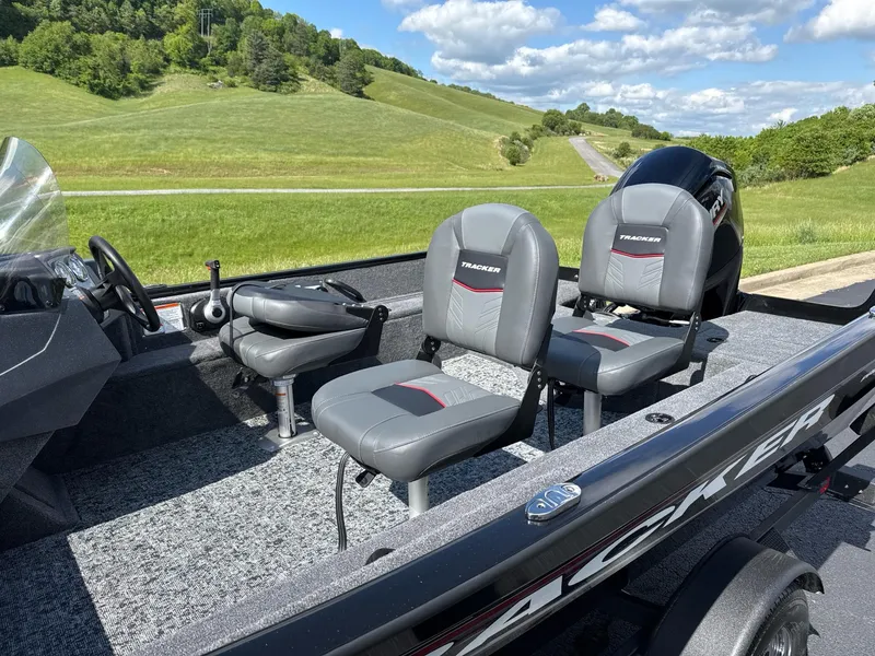 Slide: The Image of 2025 Tracker Pro Guide V-16 SC boat with gray seating, scenic green landscape background. - 4