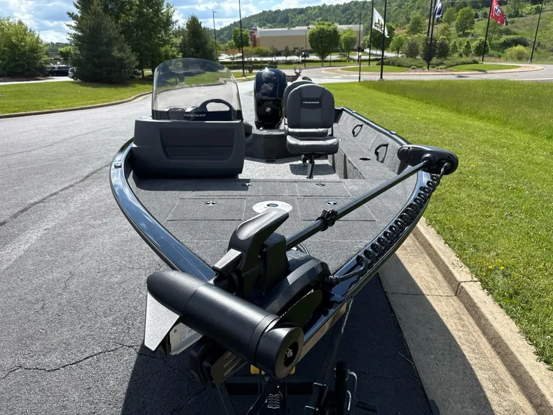 Slide: The Image of 2025 Tracker Pro Guide V-16 SC fishing boat on a sunny day, parked on a road. - 6