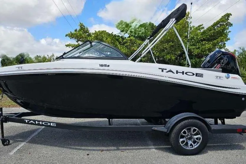 The Image of 2025 Tahoe 185 S boat on trailer, black and white design, parked outdoors. - 0