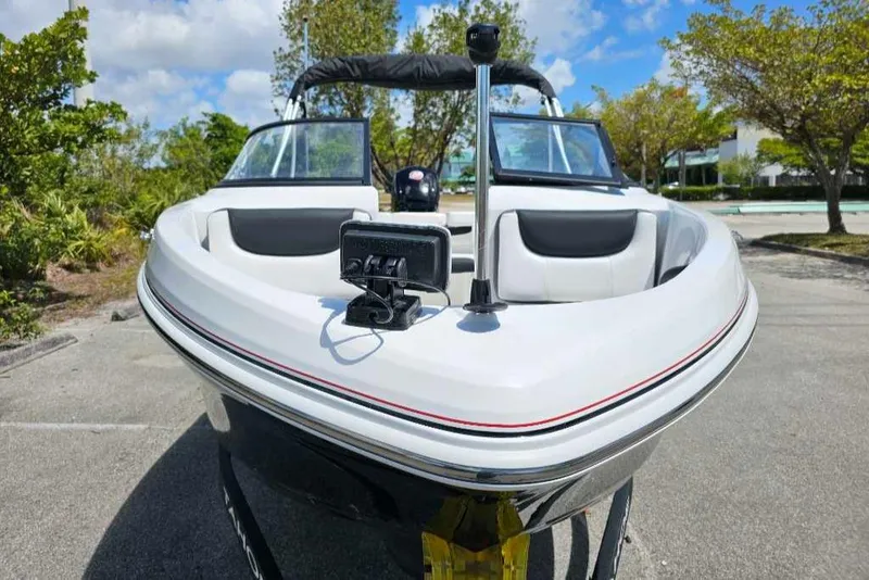 Slide: The Image of 2025 Tahoe 185 S boat, sleek design, parked outdoors under a clear blue sky. - 2