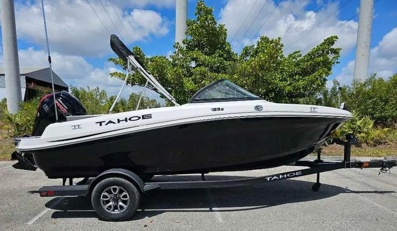 Slide: The Image of 2025 Tahoe 185 S boat on trailer, parked outdoors under a blue sky. - 91