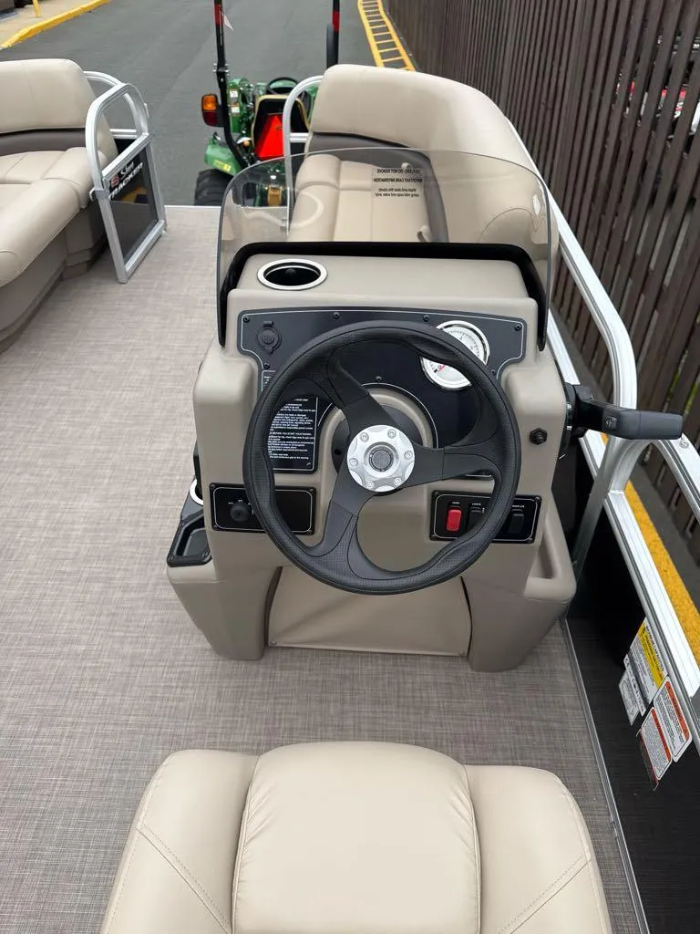 Slide: The Image of 2025 Sun Tracker Party Barge 16 DLX pontoon boat steering console with beige seating. - 5